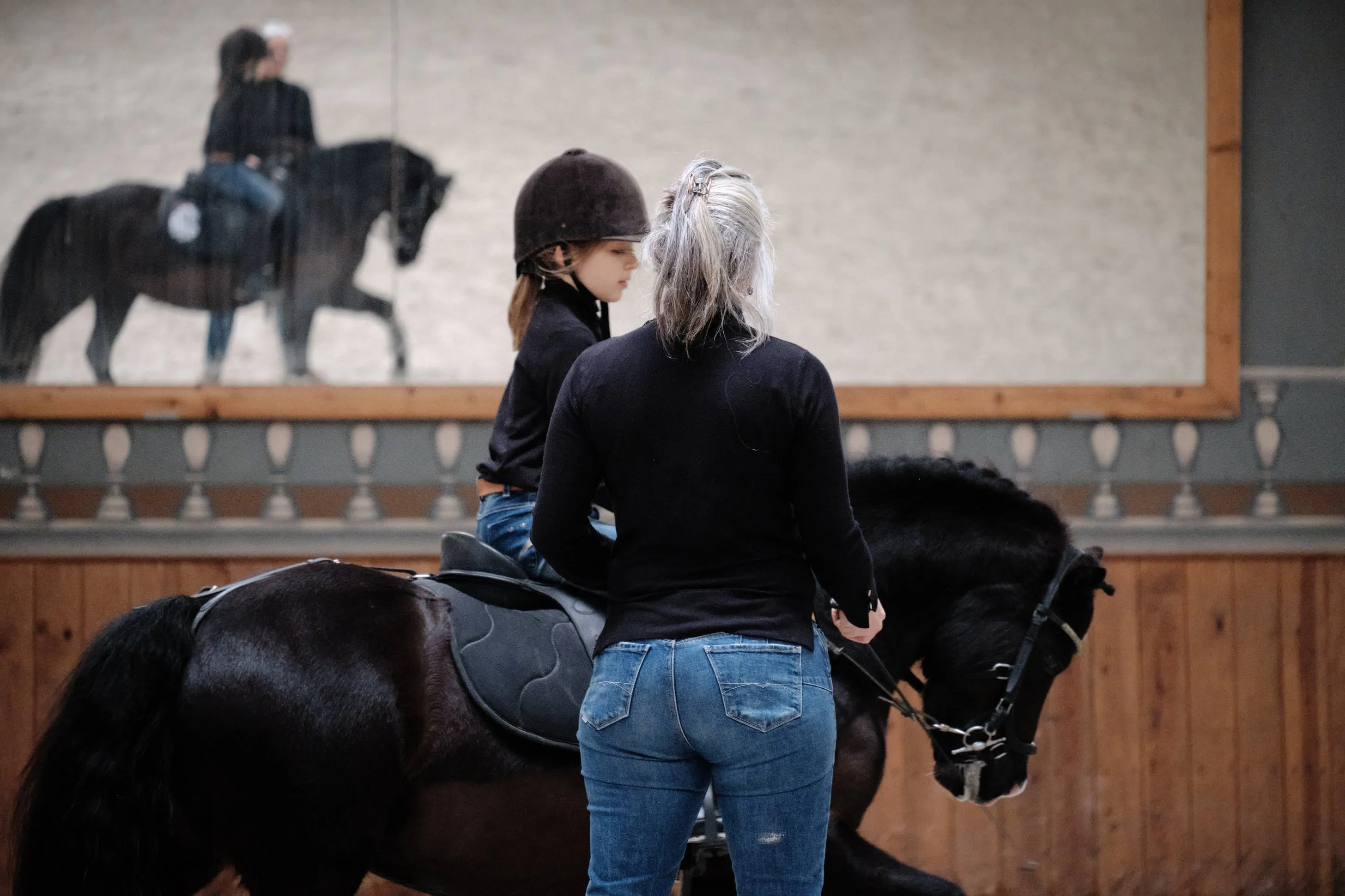 La coach donne des instructions à la jeune cavalière et à son poney